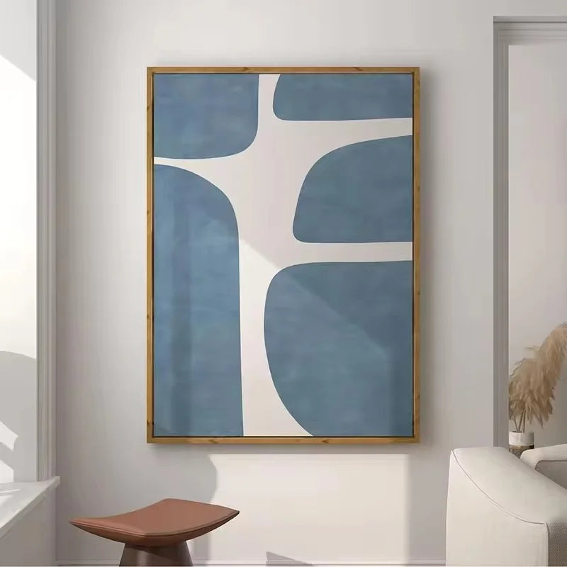 Abstract art piece with blue and white shapes in a wooden frame on a wall.