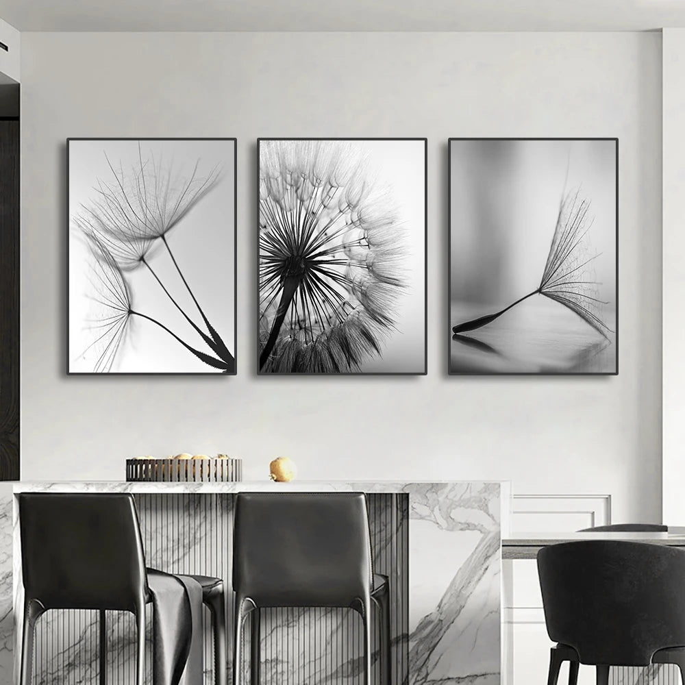 Three black and white framed artworks of dandelion seeds on a wall above a dining table.