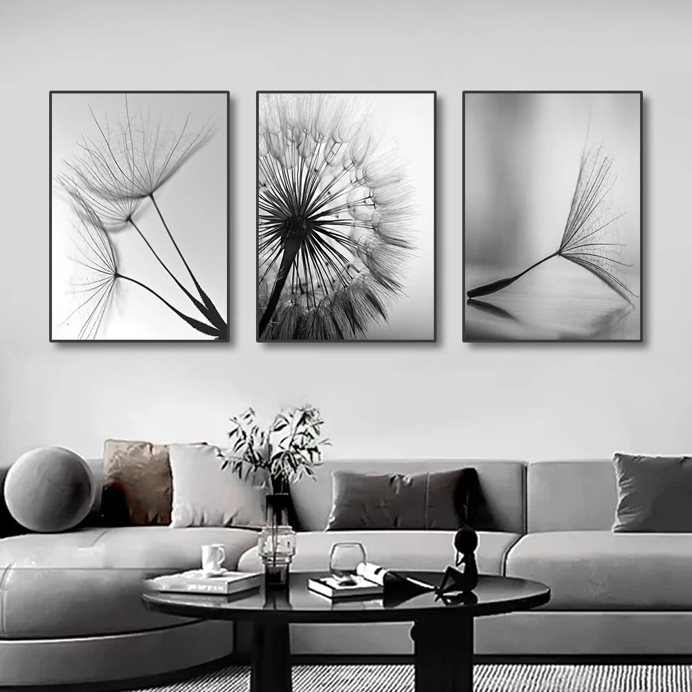 Three black and white framed artworks on a wall above a sofa.