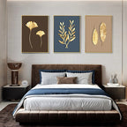 Modern bedroom with a bed, nightstands, and wall art featuring gold leaf designs.