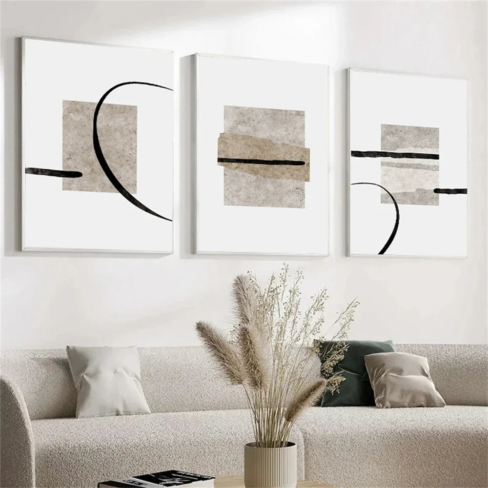 Three abstract art pieces on a wall above a sofa with decorative elements.