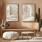 Modern interior with cacti, a pouf, and abstract wall art on a peach-colored wall.