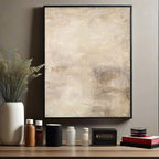 Abstract art piece on a wall with decorative items on a shelf below.