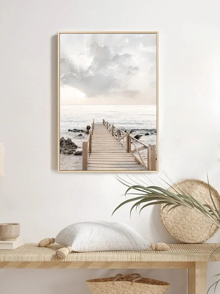 Framed beach scene print on a wall above a wooden bench with decorative items.