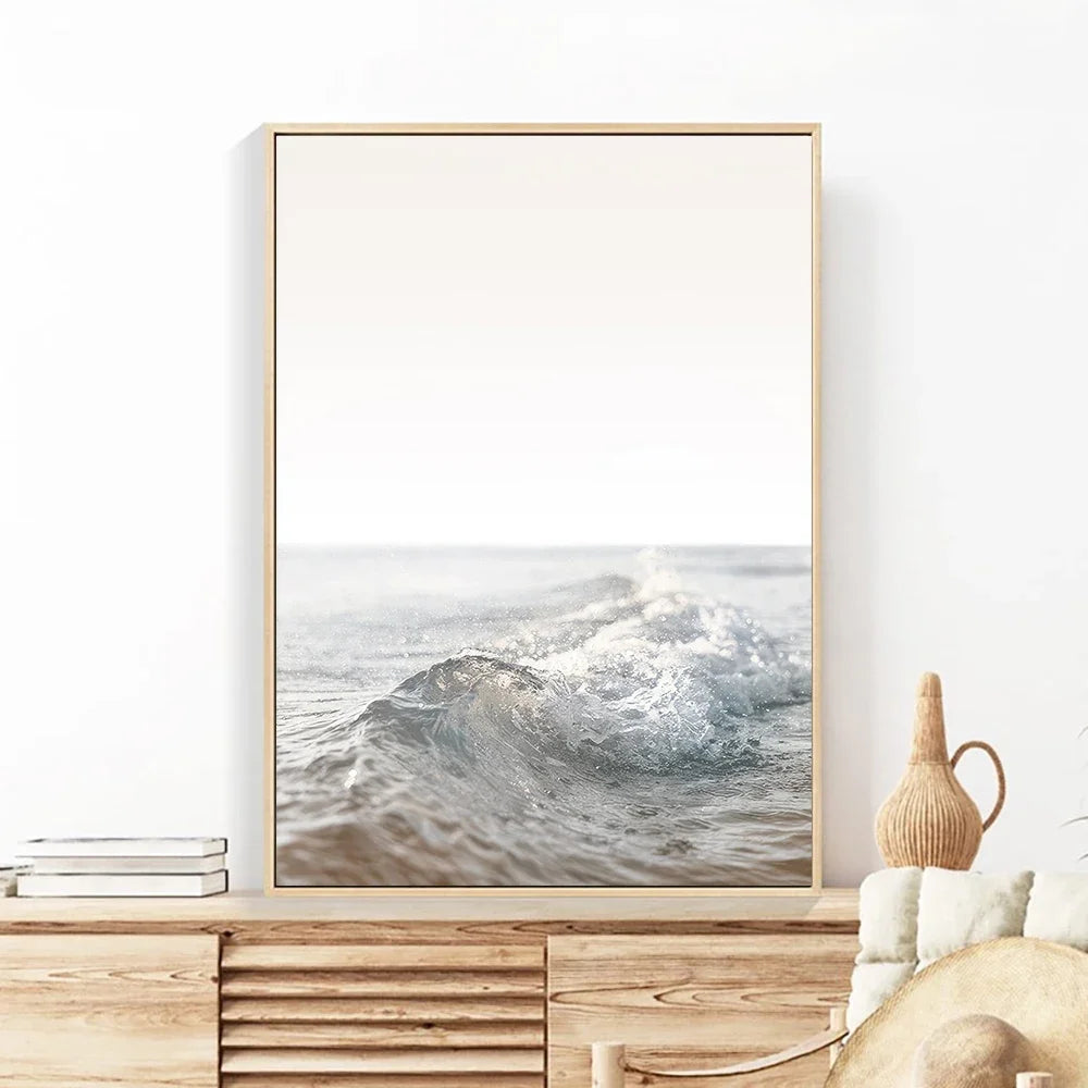 Framed artwork of a wave on a wall above a wooden cabinet.