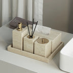 Bathroom accessories set on a tray with a neutral color scheme.
