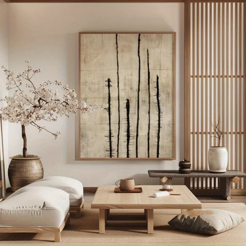 A large wall art print with vertical black brushstrokes on a textured beige background, displayed in a serene, minimalist Japanese-style living room with a low wooden table, cushions, and a blooming cherry blossom tree.