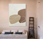 Abstract art piece on a wall above a sofa in a living room.