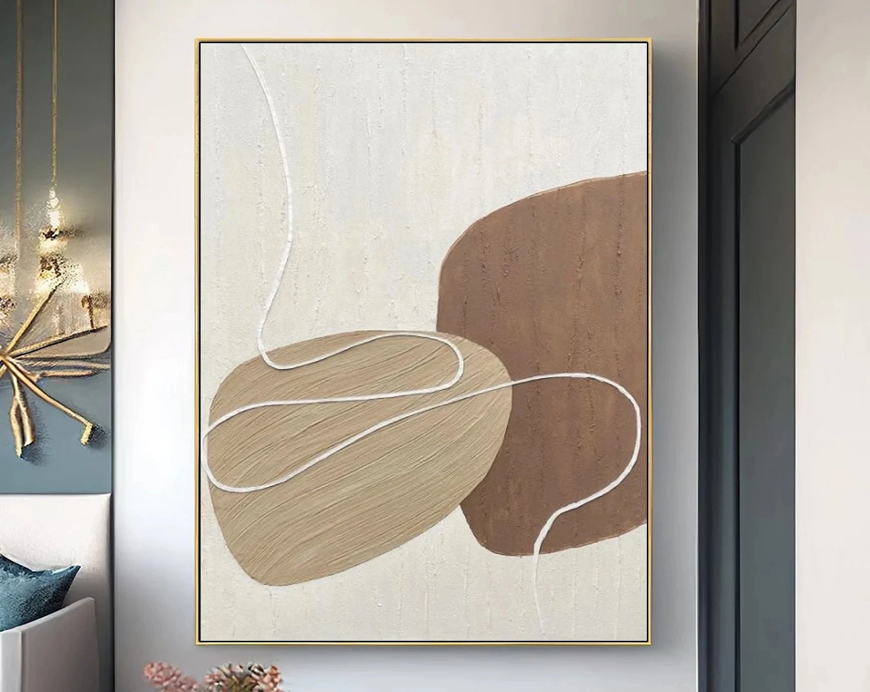 Abstract art piece with brown and beige shapes on a light background, framed in gold.