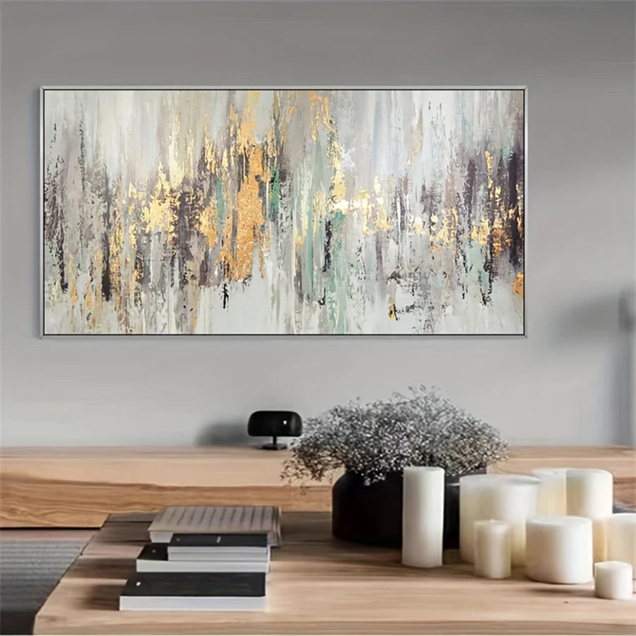 Abstract painting with gold accents on a wall above a wooden desk with decor items.