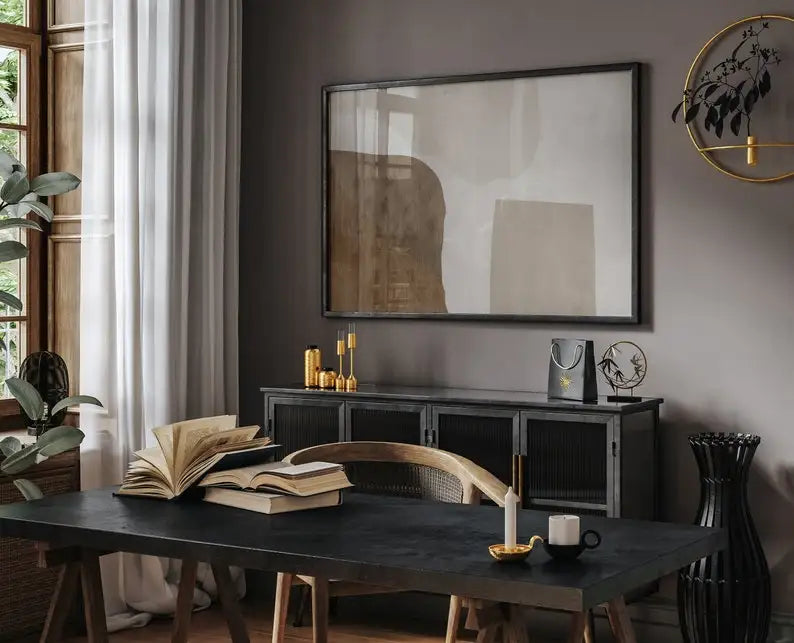 Modern interior with a black desk, books, and decorative items in a room with a large abstract painting on the wall.