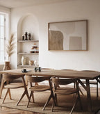 Dining room with wooden table and chairs, abstract art on the wall, and shelves with decorative items.