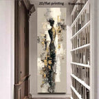 A tall vertical abstract wall art print featuring a stylized female silhouette in black, gray, white, and gold tones, displayed in a hallway between a dark wood cabinet and white bookshelves. 