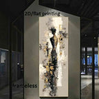 A vertical abstract canvas print featuring a stylized female figure in black, gray, white, and gold tones, displayed on a wall in a modern interior setting.