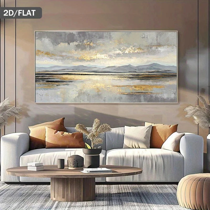 A large framed abstract landscape painting with gray, beige, and gold tones hangs above a white sofa in a modern living room. The scene includes a round wooden coffee table, neutral pillows, and dried pampas grass decor.