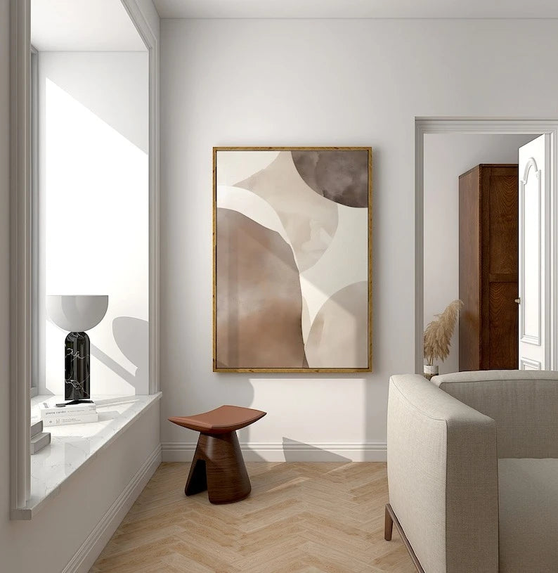 Modern interior with abstract art, stool, and sofa in a well-lit room.