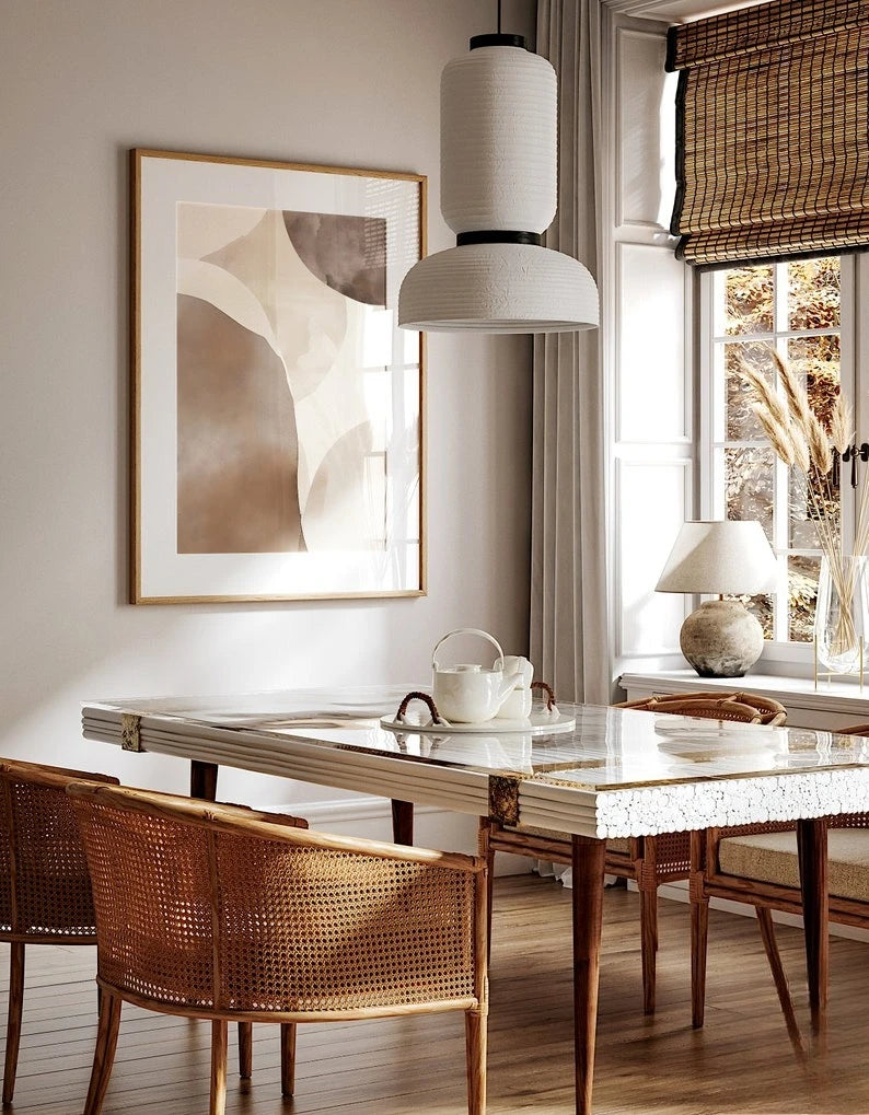Dining room with marble table, wicker chairs, and abstract art on the wall.