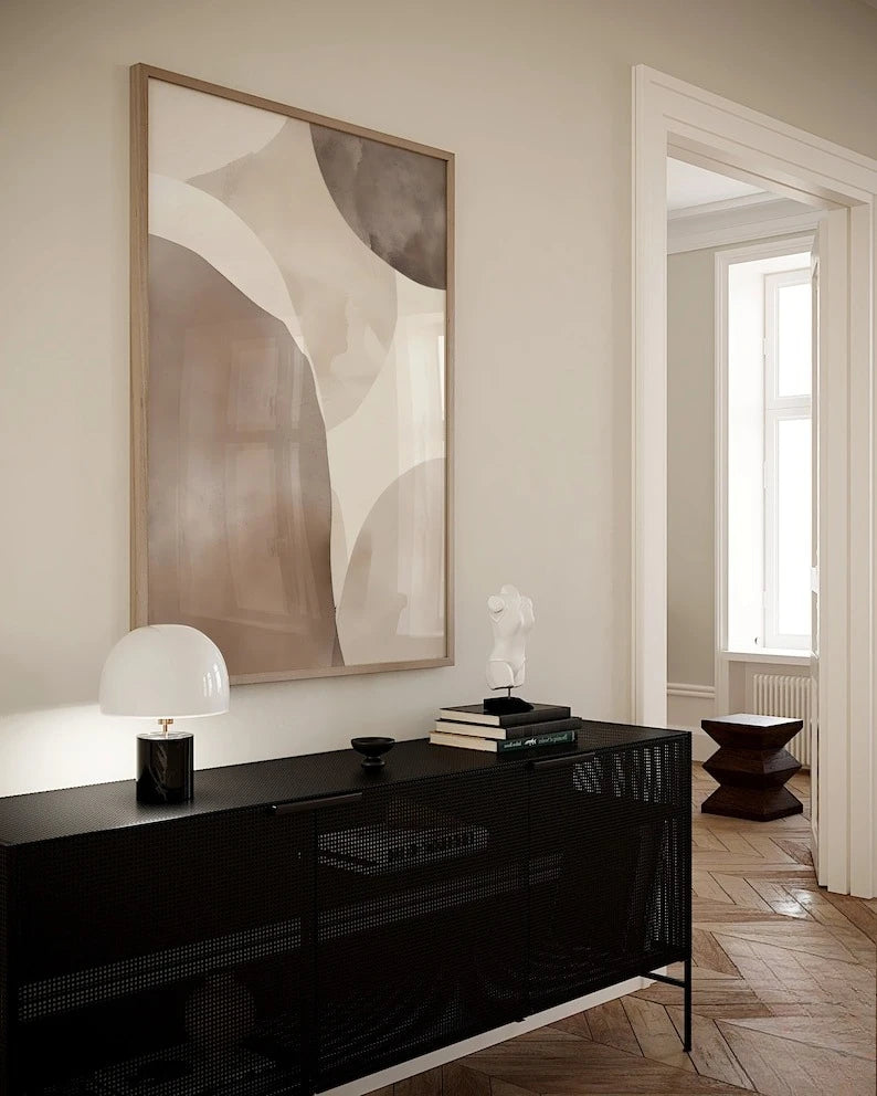 Modern interior with a black console table, abstract art, and a lamp.