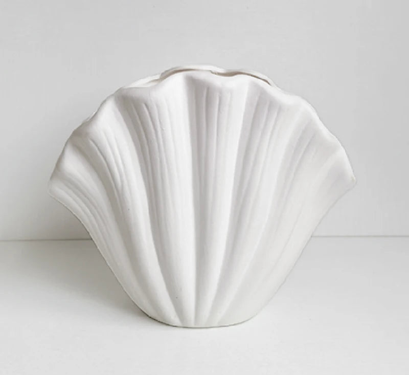 White shell-shaped ceramic vase on a light gray background