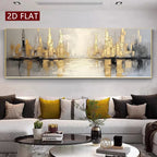 A large panoramic abstract canvas print of a city skyline with gold and gray buildings reflected in water, displayed on a light gray wall above a modern gray sofa with decorative pillows in a living room setting.