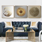 Modern living room with a blue sofa, gold coffee table, and decorative wall art.
