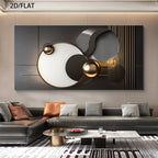 Modern abstract wall art featuring black, white, and metallic gold geometric shapes, displayed above a contemporary gray sectional sofa in a styled living room setting.