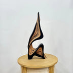 Wooden sculpture on a round wooden platform against a white background