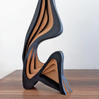 Modern, wavy-patterned vase on a wooden surface with a white background