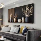 Decorative wall art with vases and plants above a gray sofa in a living room.