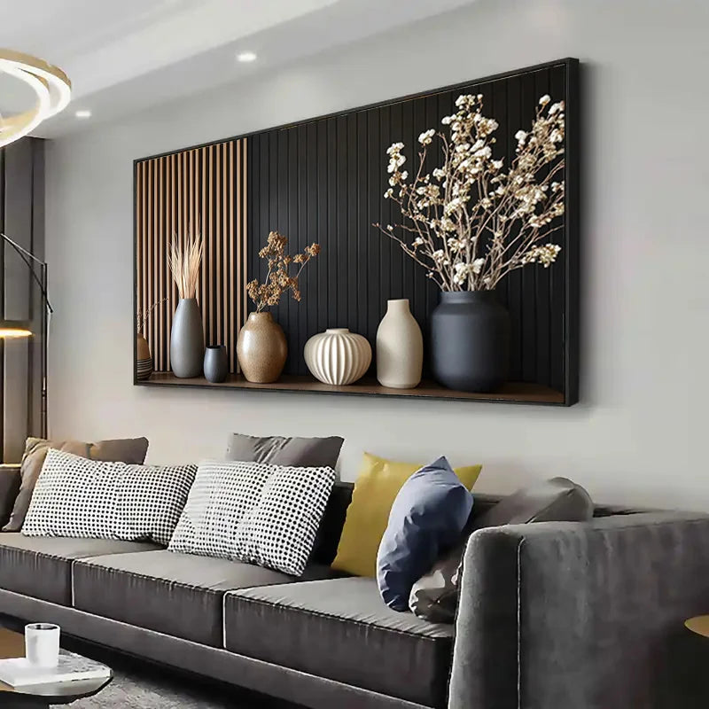 Decorative wall art with vases and plants above a gray sofa in a living room.