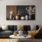 Living room with a black sofa, decorative vases, and a wall art piece.