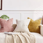 Decorative pillows on a bed with a neutral color scheme