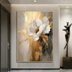 Abstract floral painting with white flowers in a gold frame on a wall.