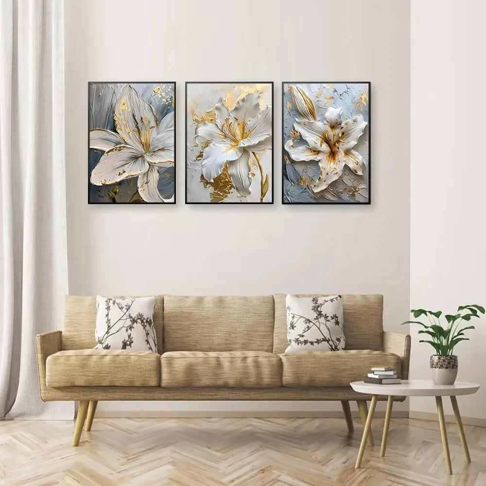 Three floral paintings above a beige sofa in a living room setting.
