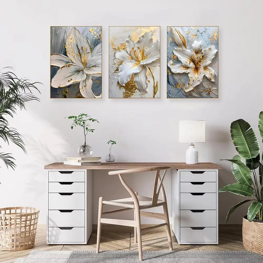 Decorative floral wall art above a desk with plants and a lamp.