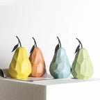Four geometric pear-shaped objects in different colors on a white surface.