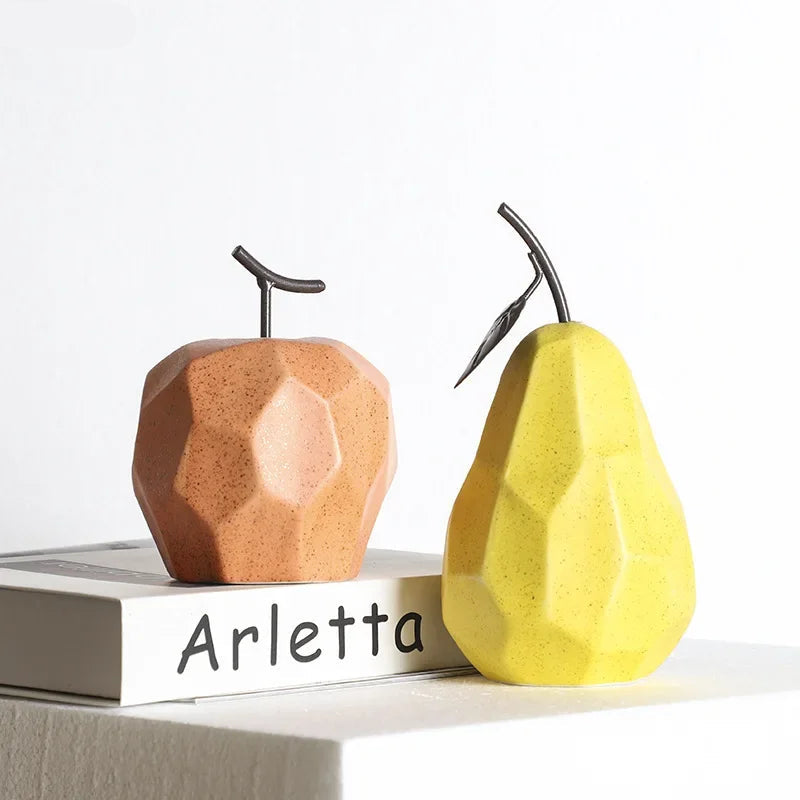 Two decorative pears, one brown and one yellow, on a white surface with 'Arletta' branding.