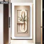 Decorative wall art with abstract design and plant on a white wall.