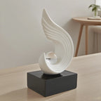 White abstract sculpture on a black base in a room setting