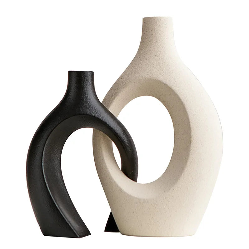 Two ceramic vases, one black and one beige, on a white background
