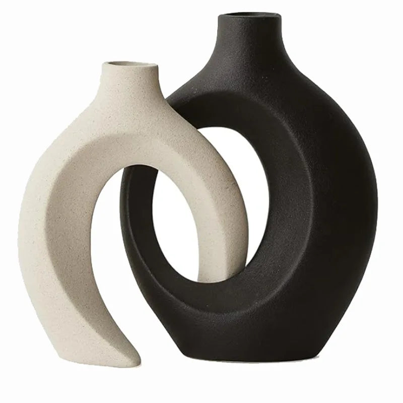 Two ceramic vases, one black and one beige, on a white background