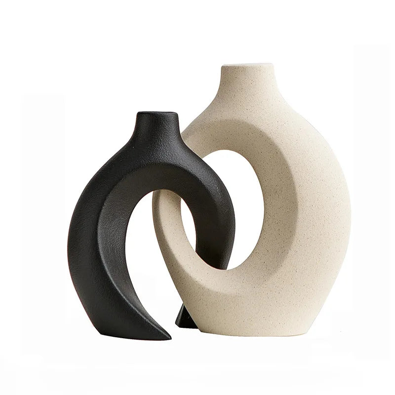 Two abstract vases, one black and one beige, on a white background