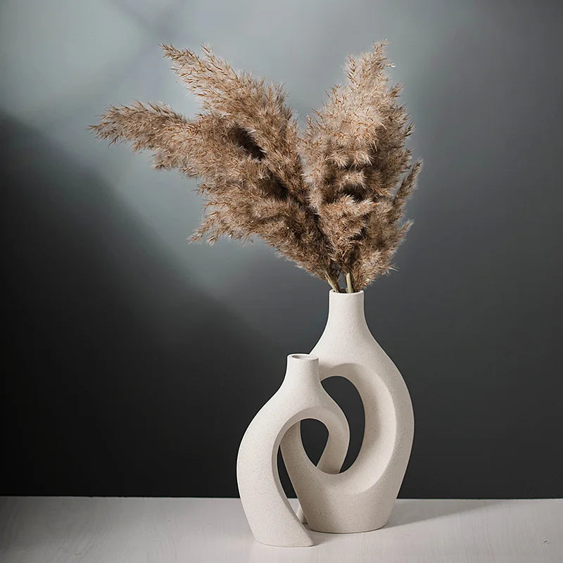 White abstract vase with dried pampas grass against a gray background