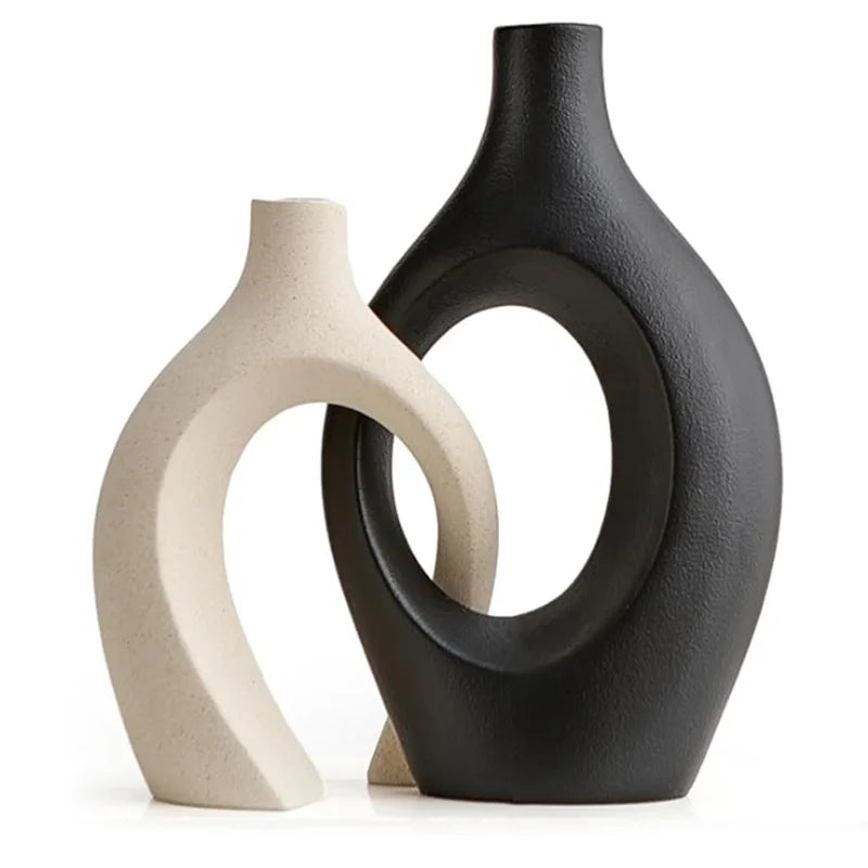 Two ceramic vases, one black and one beige, on a white background