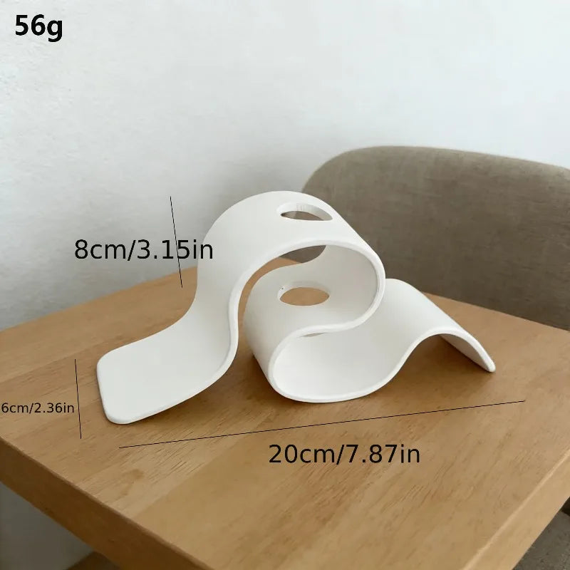 White wavy object on a wooden surface with measurements indicated