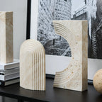 Decorative stone bookends on a table with a black and white photograph in the background.