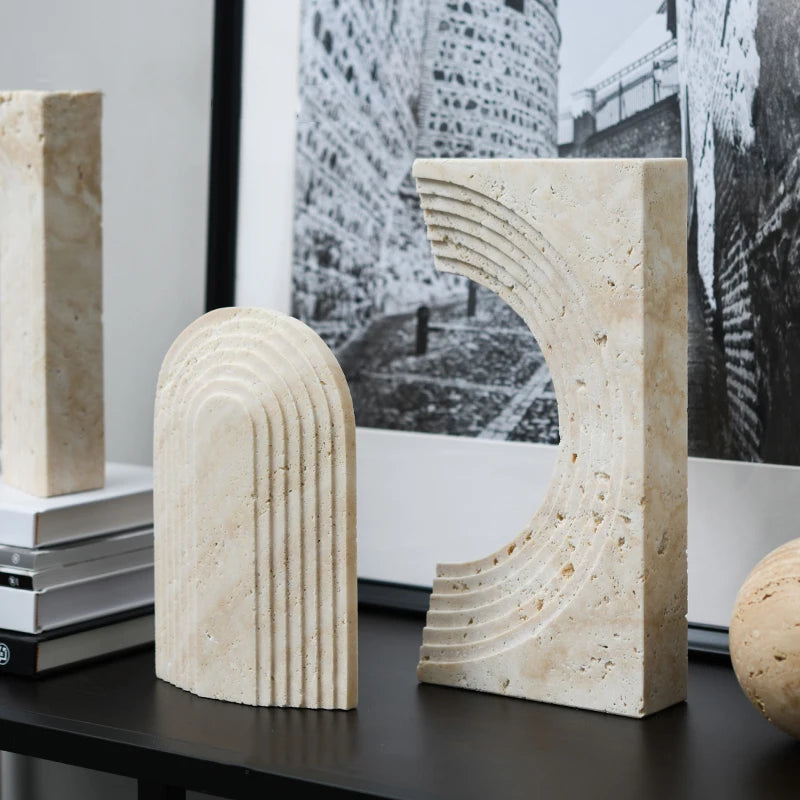 Decorative stone bookends on a table with a black and white photograph in the background.
