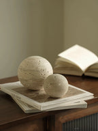 Two stone spheres on top of a book with a blurred background