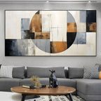 Abstract art piece on a wall above a gray sectional sofa with decorative elements.