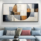 Abstract art piece on a wall above a sofa with decorative pillows.